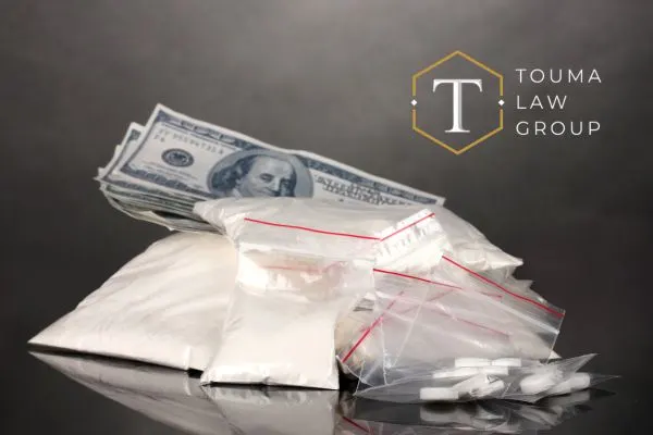 Small bags of cocaine in front of a stack of cash